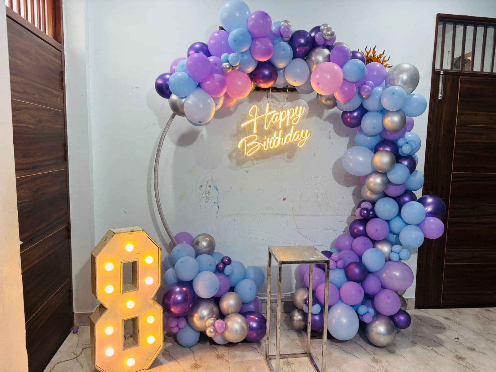 Purple, blue and silver 'Happy Birthday' balloon ring with a lit number '8'