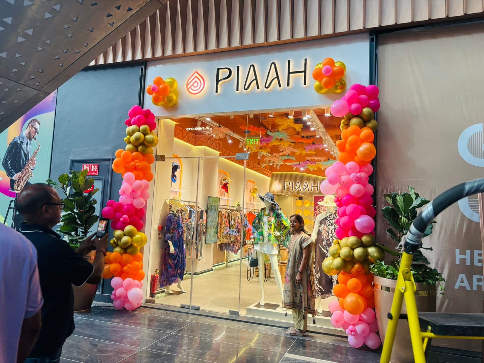 Pink and orange balloon entrance arch at a store's grand opening