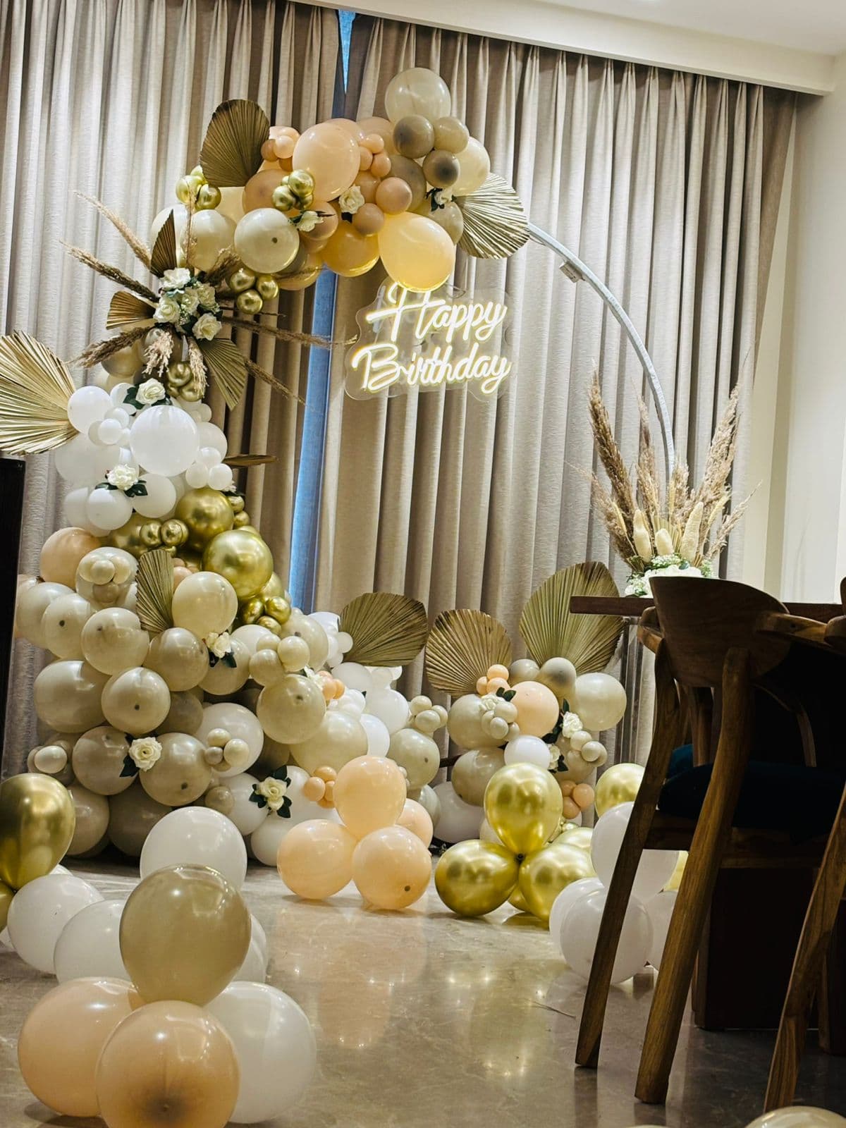 White and gold balloon arch set up for a birthday at a Gurugram home